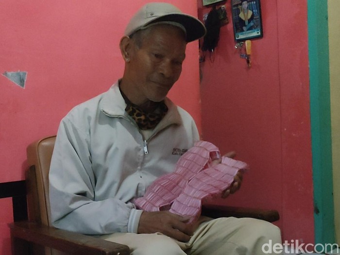 Abah Empit menunukkan hadiah yang ia terima saat bermain mesin permainan di Garut