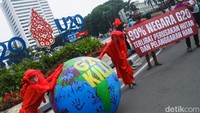 Massa membawa miniatur bumi bertuliskan G20 Kills serta spanduk berisikan tulisan 90 persen negara anggota G20 terlibat perusakan hutan dan pelanggaran HAM.