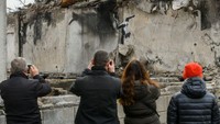 Dari rerntuhan gedung yang rusak imbas perang, beberapa warga langsung mengabadikan mural Banksy.