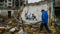 Ada juga mural yang menggambarkan seorang anak tengah membanting orang dewasa. Foto: Getty Images