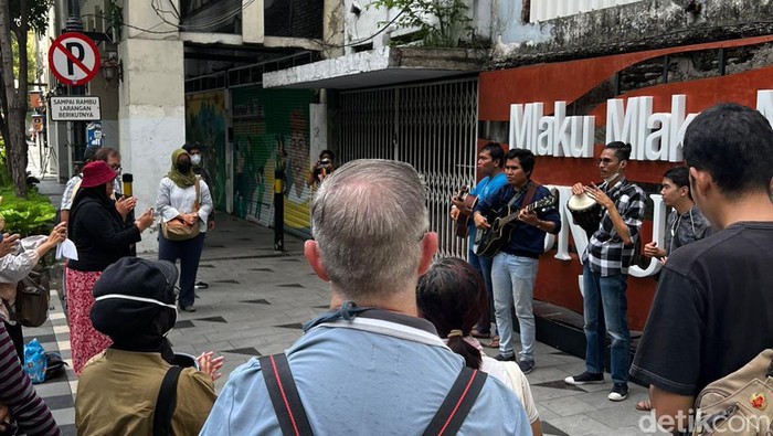 Sejumlah peserta tur menendengarkan hiburan musik dari Komunitas Mata Hati di Jalan Tunjungan Surabaya