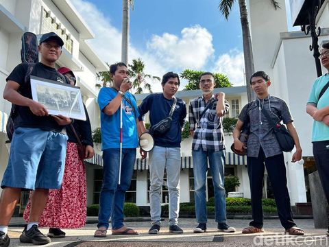 Sejumlah peserta tur menendengarkan hiburan musik dari Komunitas Mata Hati di Jalan Tunjungan Surabaya