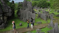 Sejumlah pengunjung melintas di area Taman Prasejarah Leang-Leang di Kabupaten Maros, Sulawesi Selatan, Minggu (13/11/2022). Jumlah kunjungan rata-rata wisatawan mencapai 800 orang lho per pekan.