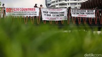 Sejumlah aktivis membentangkan spanduk sebagai bentuk protes terhadap komitmen anggota G20 dalam melawan perubahan iklim.