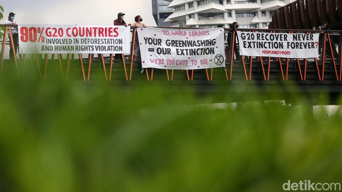 Aksi Melawan Perubahan Iklim Sambut KTT G20 Sejumlah aktivis membentangkan spanduk sebagai bentuk protes terhadap komitmen anggota G20 dalam melawan perubahan iklim di JPO Pinisi, Jalan Sudirman, Jakarta, Senin (14/11/2022). Bali kembali akan menjadi saksi komitmen-komitmen kepala negara. Kali ini pertemuan negara G20 yang merupakan penyumbang 80% emisi dunia dan merupakan penghuni 60% populasi bumi.