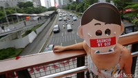 Sebagian dari mereka memakai topeng dengan mulut tertempel tulisan Silenced By G20.