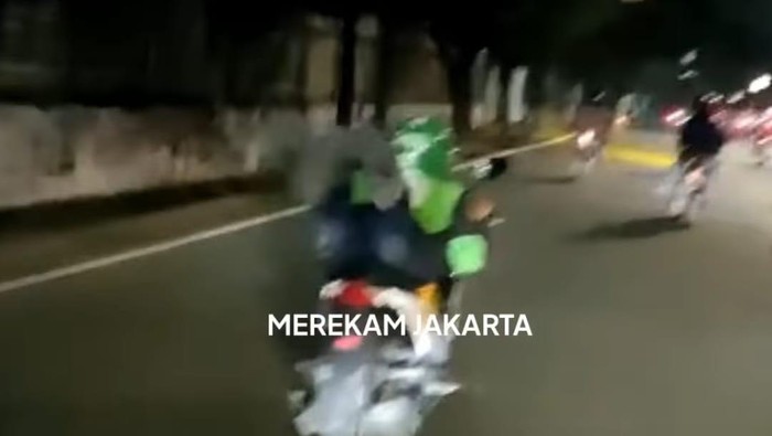Aksi ojol ugal-ugalan di jalan, tiduran di motor bak Superman.
