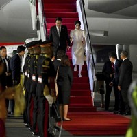 Presiden Korea Selatan Yoon Suk Yeo dan istri, Kim Keon Hee, mendarat di Bali pada Minggu (13/11/2022) malam. Keluar dari pesawat kepresidenan, keduanya terlihat rapi dalam balutan busana formal. Kim Keon Hee memakai setelan berjas gelap, sementara Kim Keon Hee memilih blus dan rok berpalet muted.    (Foto: Sonny Tumbelaka/Pool Photo via AP)