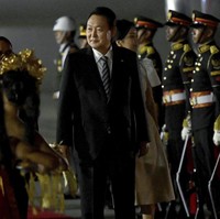 Walau berwarna kalem, busana Kim Keon Hee jauh dari kesan monoton. Blouse putih gadingnya yang bergaya safari dipadu dengan rok pensil off-white, serta stoking dan heels senada.  (Foto: Sonny Tumbelaka/Pool Photo via AP)