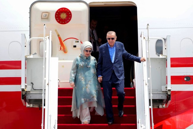 Tunik berpotongan asimetris ini memiliki dua lapis bahan dan diberi aksen kerah yang memberi kesan formal. Motif bunga membuat busana terlihat lebih dinamis. Foto: Getty Images