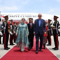 Emine Erdogan memadukan tunik dengan celana panjang warna abu-abu muda. Ia juga memakai hijab berwarna senada. Foto: Getty Images