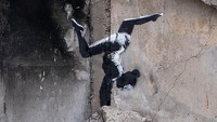 Di reruntuhan gedung yang rusak karena perang, Banksy membuat mural tentang pesenam yang sedang salto. Tangan pesenam menjadi tumpuannya seperti bagian kepala.  Foto: Banksy/ Instagram