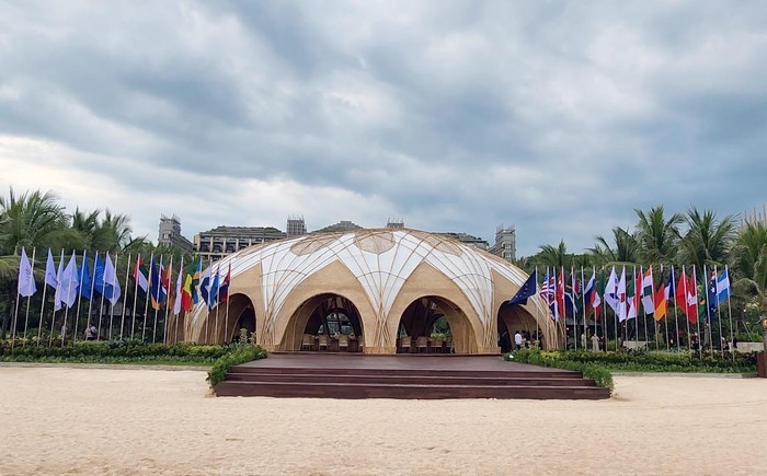 Orang-orang berjalan melewati spanduk berlogo G20 di Bali