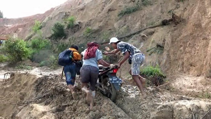 Pengendara berusaha melewati material longsor di Mamasa, Sulbar.