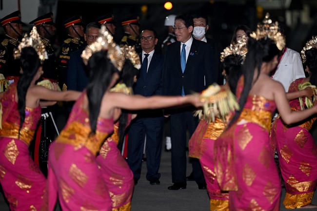 Perdana Menteri Jepang Fumio Kishida termasuk kepala negara kloter pertama yang mendarat di Bali. Ia tampak memakai setelan gelap bergaris dan dan dasi biru. Pada bagian lapel jas, tersemat pin pita pink, lambang gerakan peduli kanker payudara. (Foto: POOL/AFP via Getty Images/SONNY TUMBELAKA)