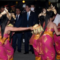 Perdana Menteri Jepang Fumio Kishida termasuk kepala negara kloter pertama yang mendarat di Bali. Ia tampak memakai setelan gelap bergaris dan dan dasi biru. Pada bagian lapel jas, tersemat pin pita pink, lambang gerakan peduli kanker payudara. (Foto: POOL/AFP via Getty Images/SONNY TUMBELAKA)