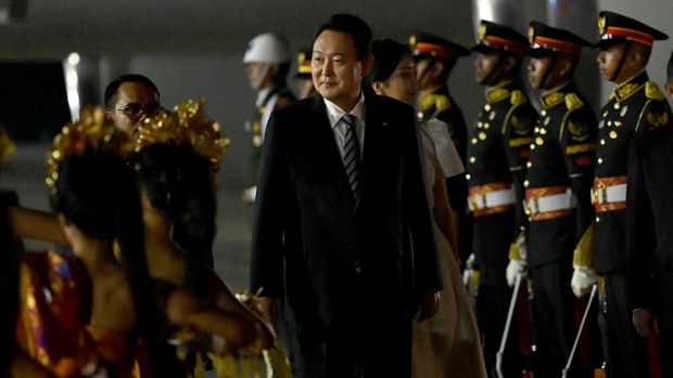 Presiden Korea Selatan Yoon Suk-yeol (tengah) tiba di bandara Internasional Ngurah Rai di Tuban, Kabupaten Badung di pulau resor Indonesia Bali, pada 13 November 2022. (SONNY TUMBELAKA/POOL/AFP via Getty Images)