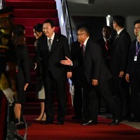 Menjadi tuan rumah KTT G20 2022 pada 15-16 November 2022, Bali kedatangan para pemimpin dunia. Salah satunya Presiden Korea Selatan Yoon Suk Yeol yang tiba di Bandara Internasional I Gusti Ngurah-Rai pada Minggu (13/11/2022). Didampingi Ibu Negara Kim Keon Hee, pria 61 tahun tampil formal dalam balutan setelan hitam berjas lengkap dengan dasi abu-abu bermotif garis hitam. (Foto: POOL/AFP via Getty Images/SONNY TUMBELAKA)