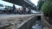 Beberapa saluran air yang hampir rampung nampak belum diberi penutup, pengemudi yang melintas nampak berhati-hati.