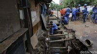 Pekerja dari Sudin Sudin Sumber Daya Air (SDA) melakukan proses rehabilitasi crossing saluran air di Jalan Buluh Perindu, Kelurahan Pondok Bambu, Duren Sawit, Jakarta Timur, Senin (14/11/2022).