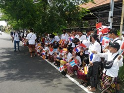 Siswa SMPN 1 Kuta Utara menyambut tamu delegasi G20 di sekitar Bandara Ngurah Rai Senin siang. Foto: Nuranda Indrajaya/detikBali