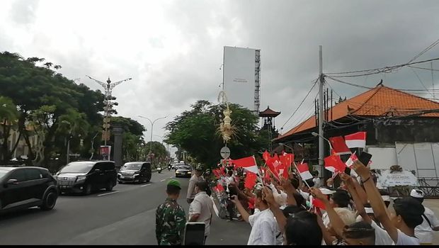 Warga Kuta dan siswa SMP menyambut kedatangan Presiden China Xi Jinping di sekitar Bandara I Gusti Ngurah Rai, Badung, Bali, Senin (14/11/2022).