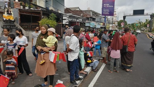 Warga Kuta dan siswa SMP menyambut kedatangan Presiden China Xi Jinping di sekitar Bandara I Gusti Ngurah Rai, Badung, Bali, Senin (14/11/2022).