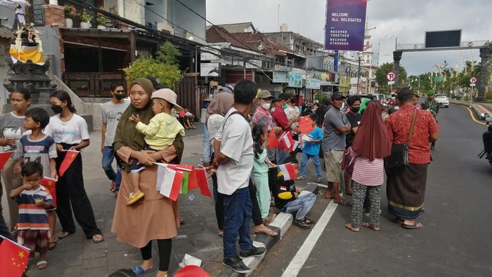 Warga Kuta dan siswa SMP menyambut kedatangan Presiden China Xi Jinping di sekitar Bandara I Gusti Ngurah Rai, Badung, Bali, Senin (14/11/2022).