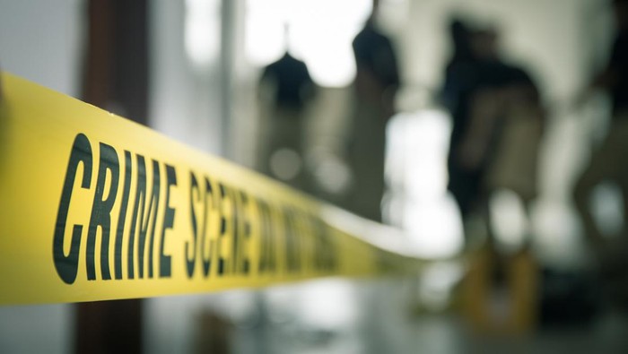crime scene tape with blurred forensic law enforcement background in cinematic tone and copy space