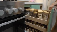 Sharena mengaku dirinya adalah ibu yang hobi memasak dengan banyak bumbu dan rempah. Untuk menyimpan rempah dan terlihat rapi, ia memanfaatkan kebinat di bagian bawah meja dapurnya. Foto: YouTube/Sharena Delon