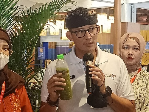 Menteri Pariwisata dan Ekonomi Kreatif (Menparekraf), Sandiaga Salahuddin Uno menunjukkan minuman loloh cemcem di Pasar Nusa Dua, Badung, Bali, Selasa (15/11/2022). (Foto: Ni Made Lastri Karsiani Putri/detikBali)