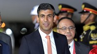 Giliran Rishi Sunak yang menginjakkan kaki di Bali. Perdana Menteri Inggris itu terlihat tersenyum di depan kamera.