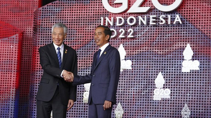 Singapores Prime Minister Lee Hsien Loong greets Indonesias President Joko Widodo as he arrives for the G20 leaders summit in Nusa Dua, Indonesia, Tuesday, Nov. 15, 2022. (Kevin Lamarque/Pool via AP)
