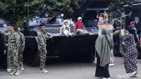 Warga khususnya anak-anak bisa foto-foto sambil naik tank.