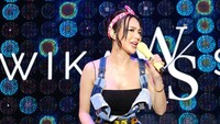 Di atas panggung, Wika Salim berpakaian biru dengan tanktop hitam, lalu ikat kepala pink, dan microphone kuning. (Foto: dok Instagram)