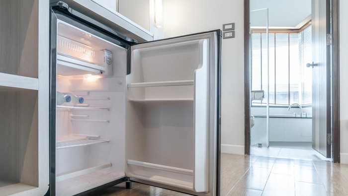 opened small refrigerator under the counter and in front of toilet in delux room at resort and hotel.
