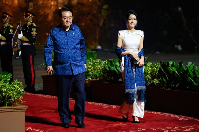 Ibu Negara Korea Selatan Kim Keon Hee tampil elegan berbalut jumpsuit putih dengan aksen shoulder pad di bahu. Foto: Getty Images/Leon Neal