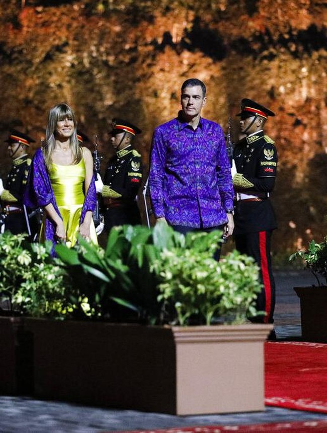 Istri Perdana Menteri Spanyol Maria Begona Gomez Fernandez menjadikan selendang tenun Bali sebagai aksen pada busananya. Ia mengenakan gaun warna shocking lemon dan menyampirkan selendang berwarna ungu terang. Foto: Dok. AP