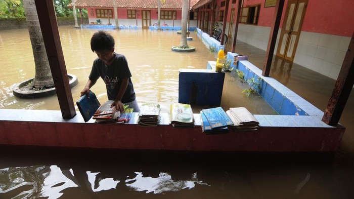 Sejumlah anak bermain di halaman Sekolah Dasar Negeri 2 Krakitan, Bayat, Klaten, Jawa Tengah, Rabu (16/11/2022). Selain intensitas hujan tinggi, buruknya saluran drainase menyebabkan air meluap sehingga membanjiri sekolahan dan rumah warga setempat. ANTARA FOTO/Aloysius Jarot Nugroho/foc.