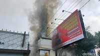 Api mulai merambat ke bagian lantai bawah dan membakar perabotan di lantai. Terdengar sirine mobil pemadam kebakaran berlalu lalang untuk memadamkan api. Foto: Tara Wahyu NV/detikJateng