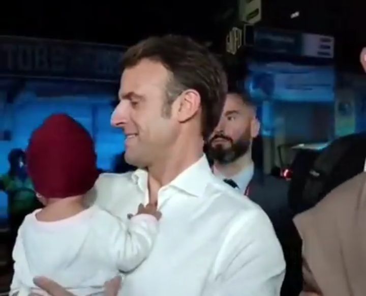 Momen ketika Macron menggendong bayi di pinggir jalan, Selasa malam (15/11/2022).