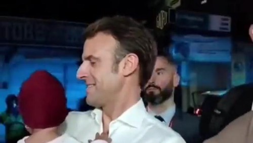 Momen ketika Macron menggendong bayi di pinggir jalan, Selasa malam (15/11/2022).