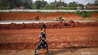 Seorang anak melintas di sekitar proyek Tol Serbaraja seksi II yang masih dalam tahap pembangunan.