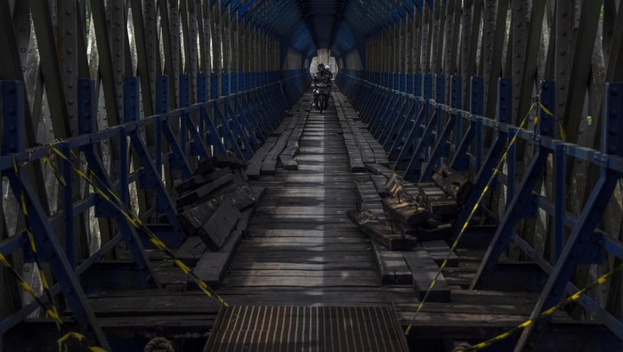 Penampakan Jembatan Cirahong yang Diperbaiki Kendaraan bermotor melewati jembatan Cirahong peninggalan masa pemerintahan Belanda tahun 1893 yang sedang diperbaiki di Panyingkiran, Kabupaten Ciamis, Jawa Barat, Rabu (16/11/2022). Perbaikan dan perawatan jembatan itu dilakukan untuk menjamin keselamatan perjalanan kereta api dan masih difungsikan untuk perlintasan kendaraan bermotor serta perlintasan kereta api di bagian atasnya. ANTARA FOTO/Adeng Bustomi/foc.