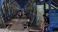 Pengendara motor melewati jembatan Cirahong yang sedang diperbaiki.