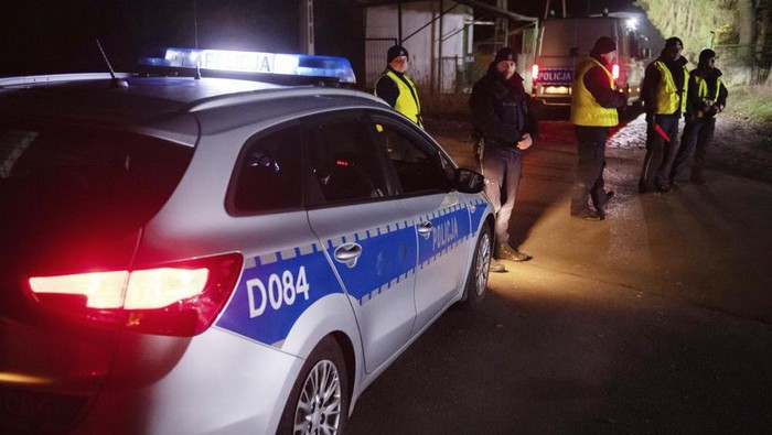 Police officers gather outside a grain depot in Przewodow, eastern Poland, on Tuesday Nov. 15, 2022 where the Polish Foreign Ministry said that a Russian-made missile fell and killed two people. The ministry said Foreign Minister Zbigniew Rau summoned the Russian ambassador and demanded immediate detailed explanations. (AP Photo)