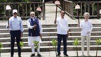 Setelah selesai, para pemimpin dunia itu mengangkat cangkul dan melihat ke arah kamera. Mast Irham/AFP/Pool/Getty Images  
