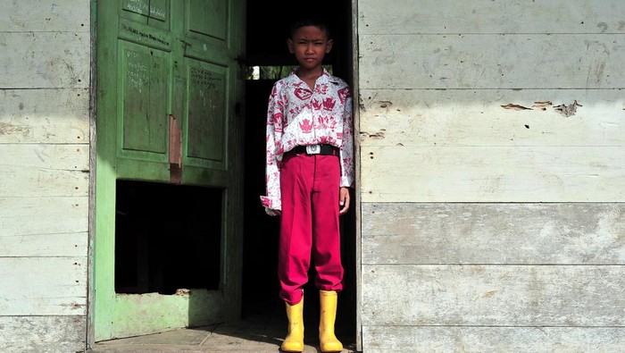 Seorang murid berdiri di depan pintu SDN 205 Sungai Sayang, Sadu, Tanjungjabung Timur, Jambi, Rabu (16/11/2022). Sekolah yang berjarak sekitar 75 kilometer dari pusat Pemerintahan Kabupaten Tanjungjabung Timur itu mengalami kerusakan di bagian atap, dinding dan sejumlah pintu sejak 3 tahun terakhir. ANTARA FOTO/Wahdi Septiawan/foc.