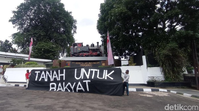 Sejumlah aktivis membentangkan spanduk di Kantor PT KAI.
