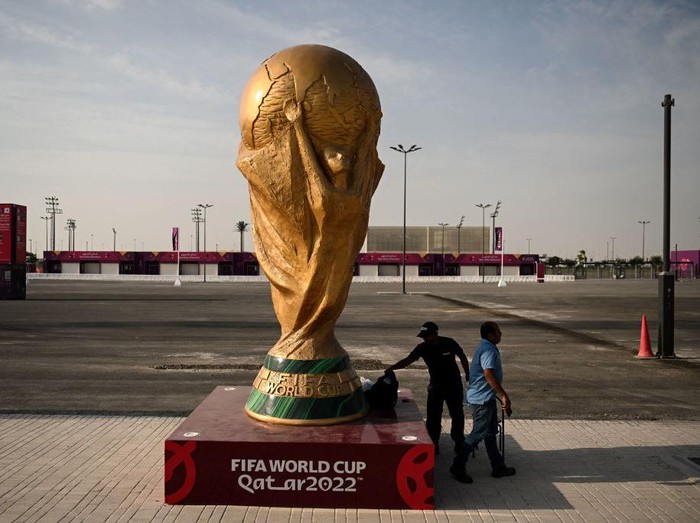 Men walk past a FIFA World Cup trophy replica outside the Ahmed bin Ali Stadium in Al-Rayyan on November 12, 2022, ahead of the Qatar 2022 FIFA World Cup football tournament. (Photo by Kirill KUDRYAVTSEV / AFP) (Photo by KIRILL KUDRYAVTSEV/AFP via Getty Images)